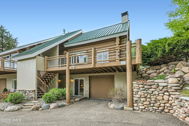 121 Hackamore Rd Unit B, Edwards, CO 81632 - view of front of house with a chimney, metal roof, log siding, a garage, and stairway