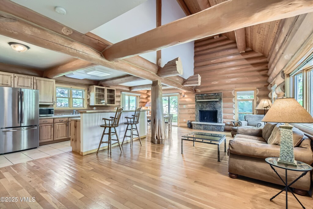 121 Hackamore Rd Unit B, Edwards, CO 81632 - living area featuring rustic walls, light wood finished floors, a stone fireplace, and plenty of natural light