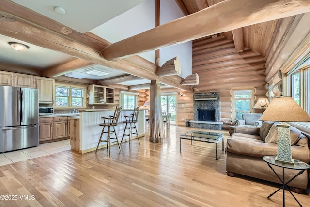121 Hackamore Rd Unit B, Edwards, CO 81632 - living area featuring rustic walls, light wood finished floors, a stone fireplace, and plenty of natural light