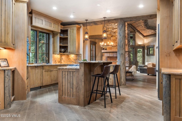 12 Cabin Creek Ln, Edwards, CO 81632 - kitchen featuring healthy amount of natural light, a kitchen breakfast bar, recessed lighting, light stone counters, and light wood-type flooring
