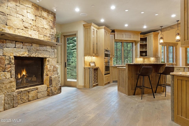 12 Cabin Creek Ln, Edwards, CO 81632 - kitchen featuring stainless steel double oven, a kitchen bar, light stone counters, open shelves, and open floor plan