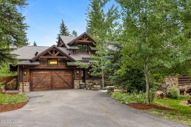 12 Cabin Creek Ln, Edwards, CO 81632 - view of front of property featuring asphalt driveway, stone siding, and a garage