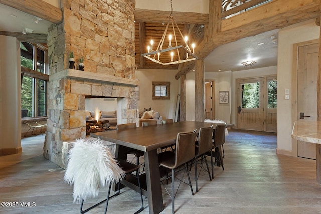 12 Cabin Creek Ln, Edwards, CO 81632 - dining room with light wood-type flooring, a chandelier, a towering ceiling, and a stone fireplace