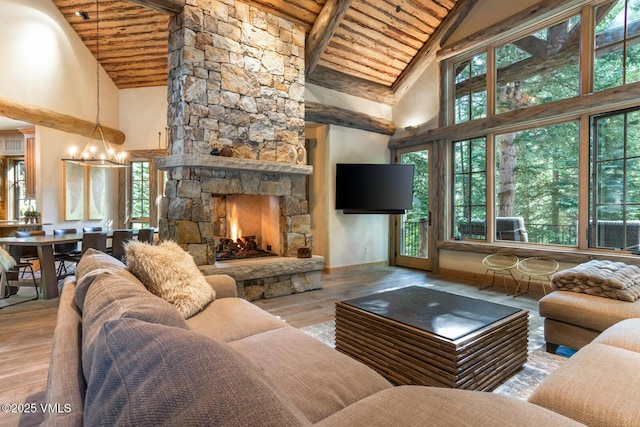 12 Cabin Creek Ln, Edwards, CO 81632 - living area with a wood ceiling with exposed beams, high vaulted ceiling, a chandelier, wood finished floors, and a stone fireplace