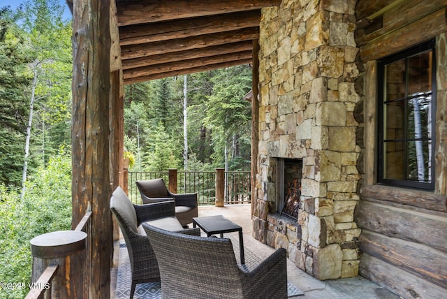 12 Cabin Creek Ln, Edwards, CO 81632 - view of patio / terrace featuring an outdoor stone fireplace and a wooded view