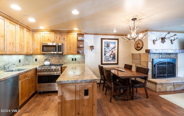 595 Vail Valley Dr Unit 115, Vail, CO 81657 - kitchen featuring stainless steel appliances, a sink, dark wood finished floors, a chandelier, and crown molding