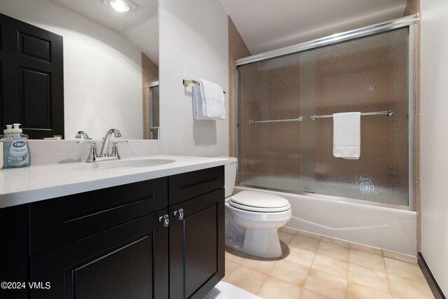 full bathroom with enclosed tub / shower combo, vanity, toilet, and tile patterned floors