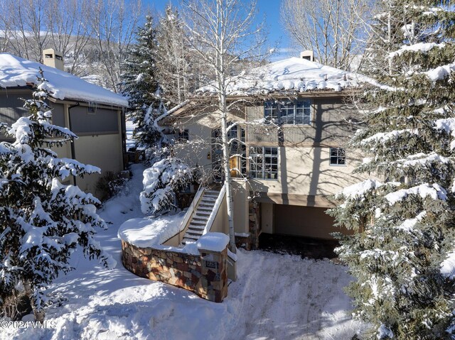 snow covered property featuring a garage