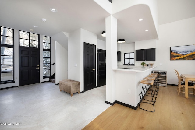 kitchen featuring wine cooler, a breakfast bar area, and kitchen peninsula