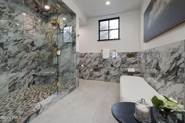 bathroom featuring a shower with shower door and tile walls