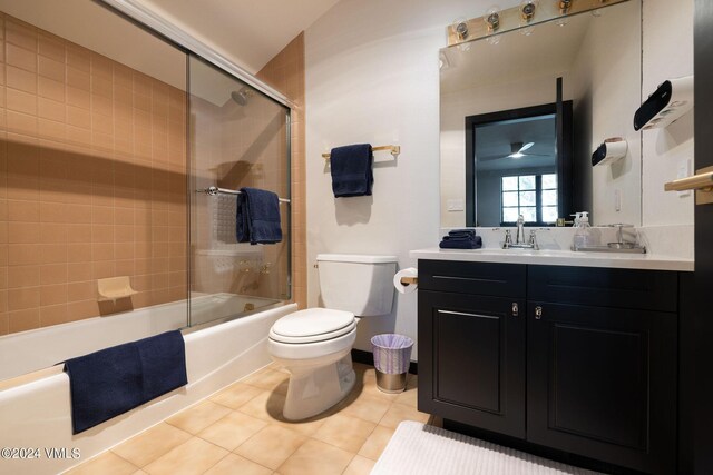 full bathroom featuring tile patterned flooring, vanity, tiled shower / bath combo, and toilet