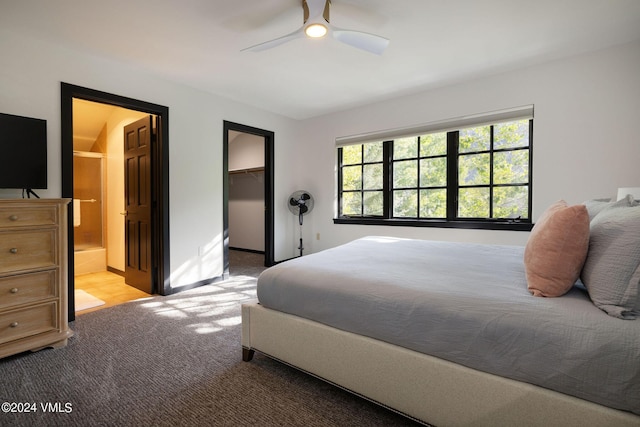 bedroom featuring a walk in closet, ensuite bath, light carpet, a closet, and ceiling fan