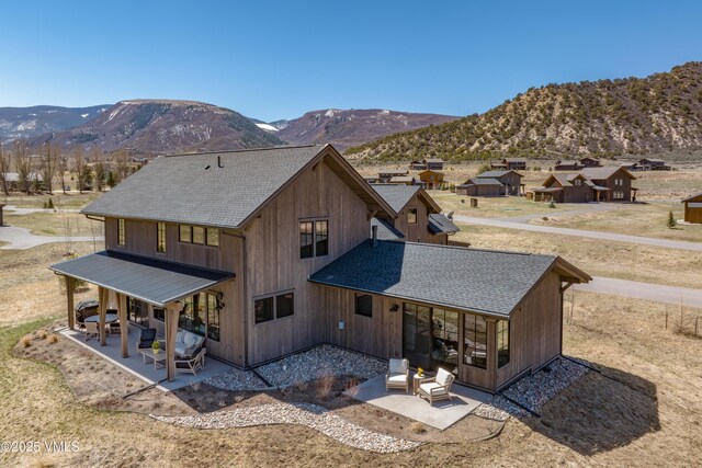 687 Hunters View Ln, Eagle, CO 81631 - back of house with roof with shingles, a mountain view, and a patio