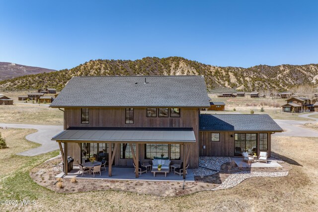 687 Hunters View Ln, Eagle, CO 81631 - rear view of property featuring a mountain view, an outdoor hangout area, roof with shingles, and a patio