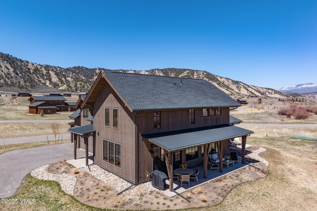 687 Hunters View Ln, Eagle, CO 81631 - rear view of house featuring a mountain view, a shingled roof, and a patio area