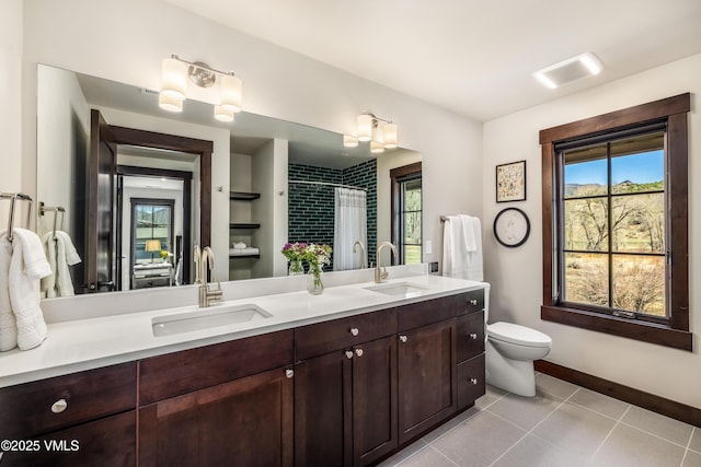 687 Hunters View Ln, Eagle, CO 81631 - full bathroom with tile patterned floors, toilet, double vanity, a shower with shower curtain, and baseboards