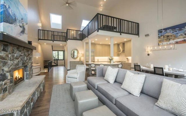 living room with a fireplace, wood-type flooring, and ceiling fan