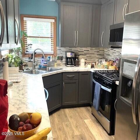 697 Schoolside St, Gypsum, CO 81637 - kitchen featuring stainless steel appliances, gray cabinets, light countertops, and light wood-style flooring