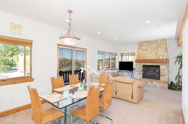 carpeted dining area with a fireplace