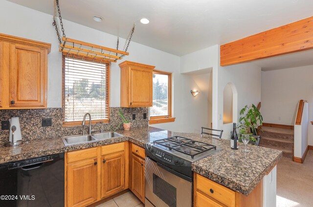 kitchen featuring sink, stainless steel gas stove, black dishwasher, kitchen peninsula, and decorative backsplash