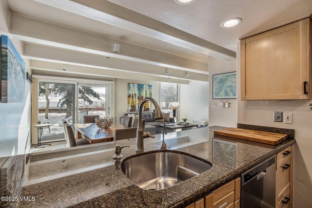 kitchen featuring dark stone countertops, sink, dishwasher, and light brown cabinets