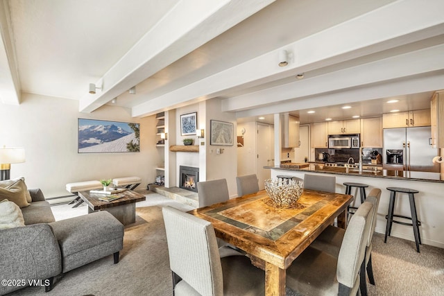 dining space featuring a baseboard radiator, light colored carpet, and beamed ceiling