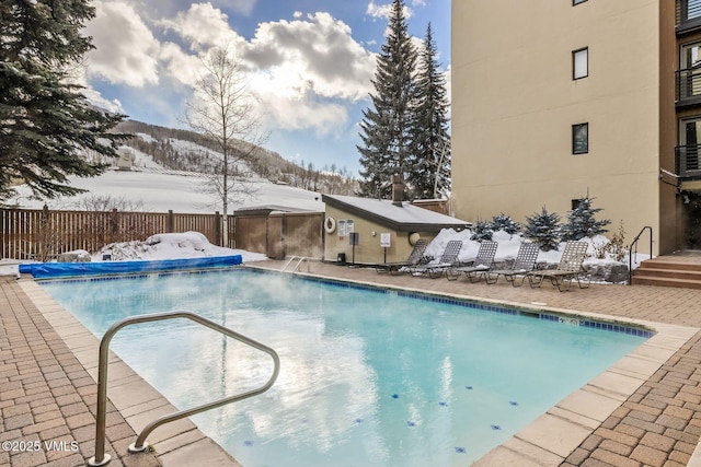 snow covered pool featuring a mountain view