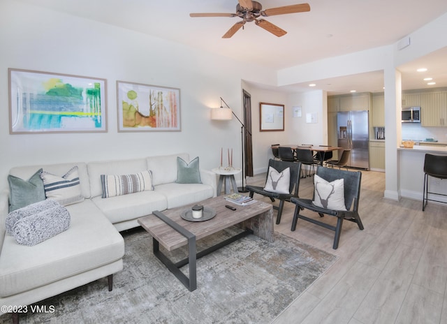 living room with ceiling fan and light wood-type flooring