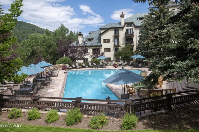 view of swimming pool with a patio and a mountain view