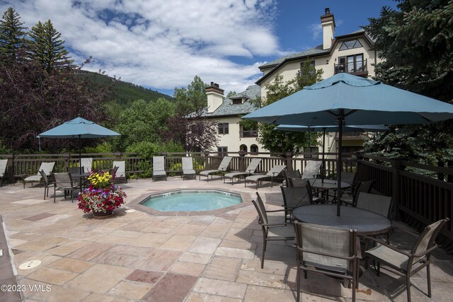 view of pool with a mountain view, a hot tub, and a patio