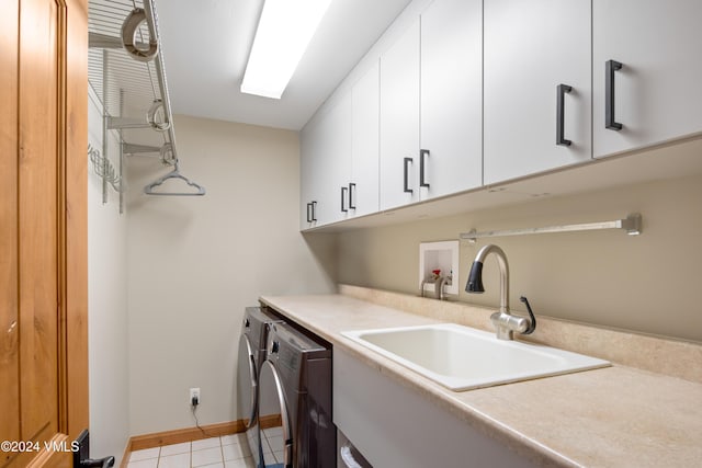 clothes washing area featuring cabinets, sink, light tile patterned floors, and independent washer and dryer