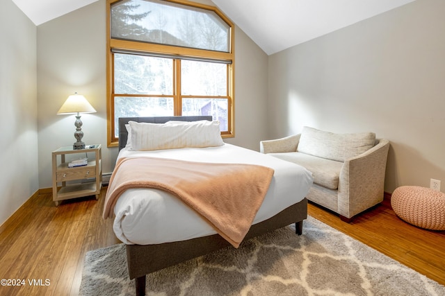 bedroom with hardwood / wood-style flooring and vaulted ceiling