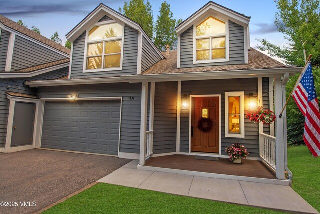 405 Greenwaye Cir Unit 11-A, Eagle-Vail, CO 81620 - view of front facade with asphalt driveway, a shingled roof, a porch, and an attached garage