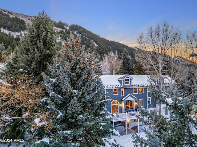 snow covered property featuring a deck with mountain view