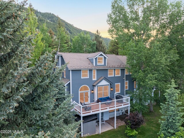 405 Greenwaye Cir Unit 11-A, Eagle-Vail, CO 81620 - back of property at dusk with a wooden deck and a patio