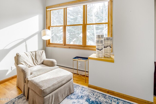 sitting room with a baseboard radiator and light hardwood / wood-style floors