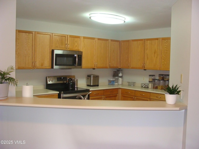 1902 Crazy Horse Cir, Edwards, CO 81632 - kitchen with stainless steel appliances, light countertops, a sink, and a peninsula