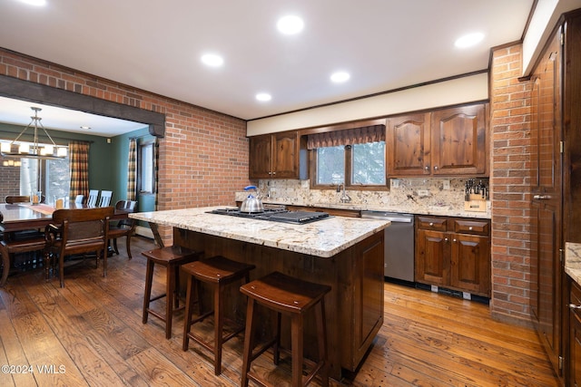 kitchen featuring dishwasher, light stone countertops, a center island, and dark hardwood / wood-style flooring