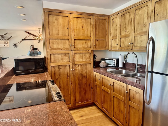 1100 N Frontage Rd Unit 1519, Vail, CO 81657 - kitchen featuring freestanding refrigerator, black microwave, brown cabinetry, stove, and recessed lighting