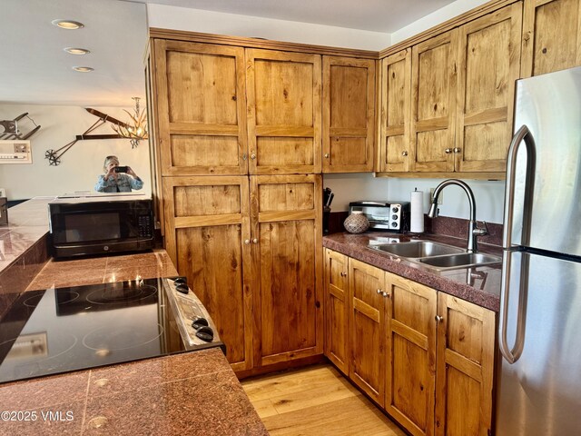 1100 N Frontage Rd Unit 1519, Vail, CO 81657 - kitchen with freestanding refrigerator, black microwave, brown cabinets, range with electric stovetop, and recessed lighting