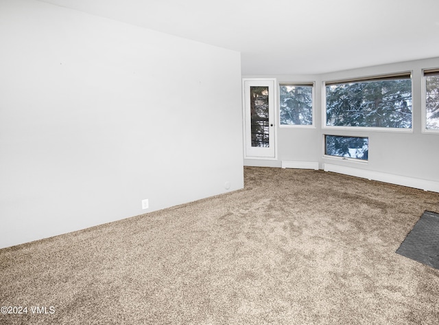 unfurnished living room featuring a baseboard radiator and carpet flooring