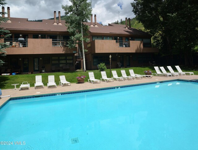 view of swimming pool featuring a yard