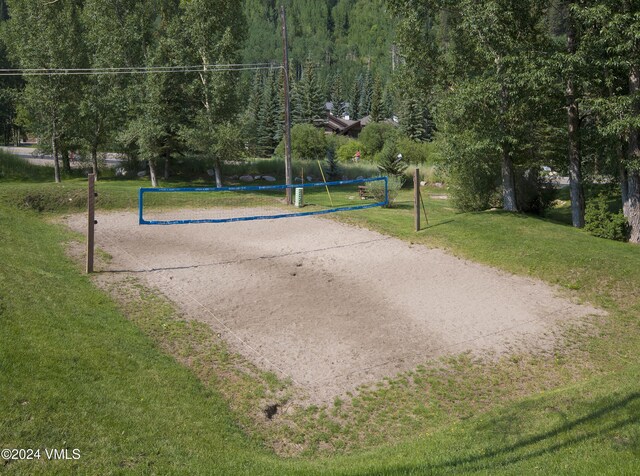 surrounding community with a yard and volleyball court