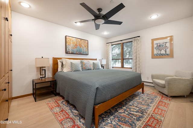 bedroom with a baseboard heating unit, hardwood / wood-style floors, and ceiling fan