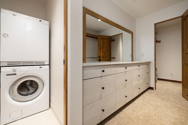 laundry area featuring light colored carpet and stacked washing maching and dryer