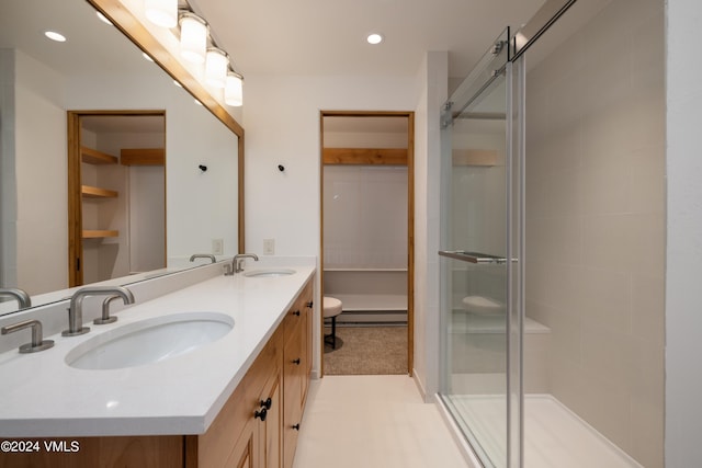 bathroom featuring vanity, toilet, a baseboard radiator, and a shower with shower door