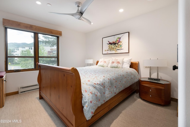 carpeted bedroom with baseboard heating, ceiling fan, and a mountain view