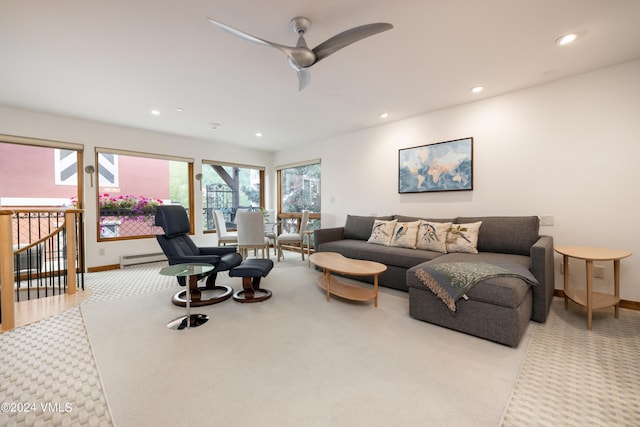 carpeted living room with ceiling fan and a baseboard radiator