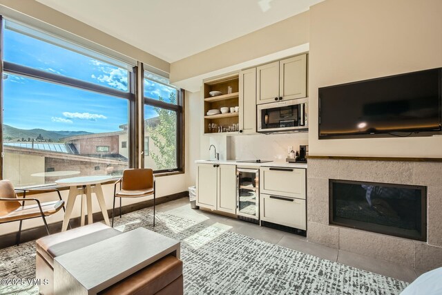 126 Riverfront Ln Unit 345, Avon, CO 81620 - living room with beverage cooler, a mountain view, light tile patterned floors, wet bar, and built in shelves