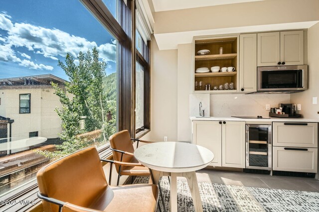 126 Riverfront Ln Unit 345, Avon, CO 81620 - indoor wet bar featuring wine cooler, stainless steel microwave, tasteful backsplash, and light tile patterned floors